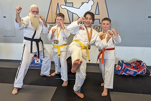 Seven students of Aurora’s ATA Martial Arts got off on the right foot in their first competition, placing and medaling at the Lincoln Gold Star Martial Arts Class C Tournament. From left, Master Vern Larson and students Jonah Sigears, Adrik Diaz and Gage Bright kick up their heels as they celebrate their first successful competition.