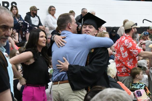During the exchange of roses from the graduating seniors and their family members, Phillip Kreutz embraced his father Jim. Alongside his father his mother, Jaime.