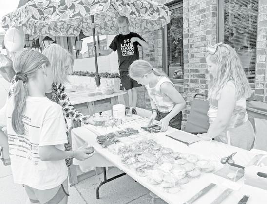 The young trio of Addisyn Lanham, Bailey Lange and Sam Jones spent Thursday afternoon selling baked goods and ice cold lemonade in efforts to raise money for the Aurora-Adopt-A-Pet and COVID relief for Westfield and MCHI. News-Register/Richard Rhoden