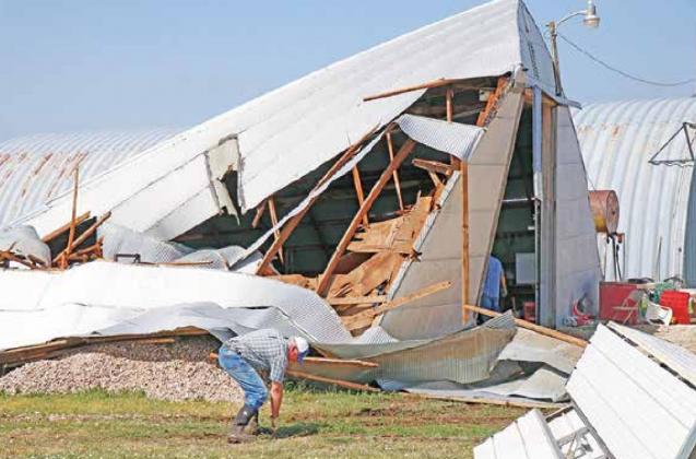 This quonset was one of several parts of the Mickey property that was damaged during the Sunday morning storm. Though no tornado was confirmed, Barbie Mickey noted the wind sounded like a freight train. Clint Mickey’s father, Curt, is seen here helping clean up Sunday. News-Register/Cheyenne Rowe