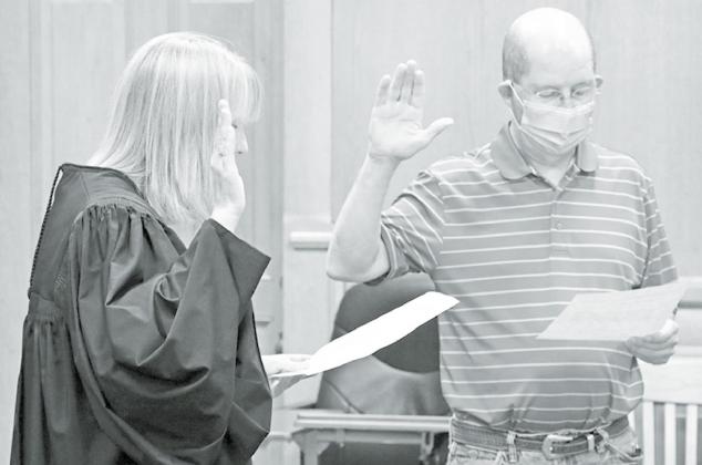 Judge Rachel Daugherty (left), raises her right hand and recites the oath of office with newly appointed District 3 Commissioner John Thomas. News-Register/Cheyenne Rowe