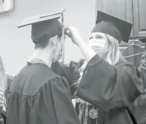 Kaley Ballard (right) helps Kyle Phillips straighten out his cap in the moments leading up to an anticipated ceremony Sunday in Giltner. News-Register/Richard Rhoden