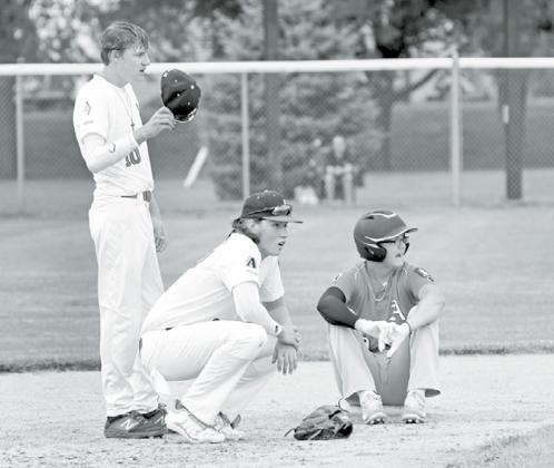 From left, PB White’s Cayden Phillips, Cam Jones and AC Red’s Kyle Larson catch their breath as a new pitcher warms up mid-game. News-Register/Richard Rhoden