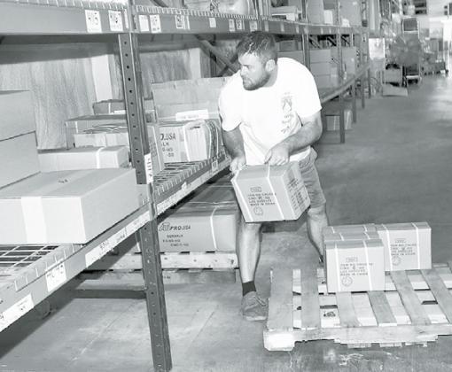 Dan Kaminski moves packaged product to the shelves in one of 1st Web Sales’ two large warehouses located on Highway 14 just south of Aurora. News-Register/Kurt Johnson