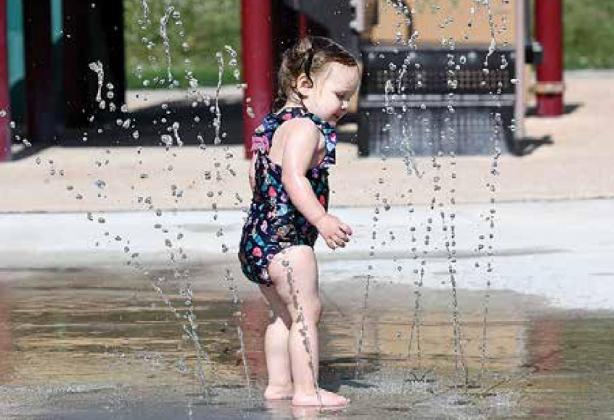 Arya Bennett, the young daughter of Jeremiah and Sarah Bennett, was among the first to seek relief from the hot summer sun with Monday’s opening of the Cole Park splash pad. The automated water features are active from 10:30 a.m. to 8:30 p.m. daily. News-Register/Kurt Johnson