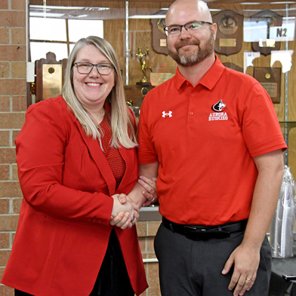 Nebraska School Counselor Association Executive Director Malinda Jean Baptiste congratulates Aurora High School Counselor Jacob Willems after naming him as the Nebraska School Counselor of the Year for 2026.  