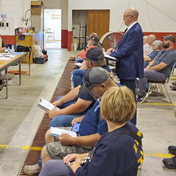 Gothenburg attorney Mike Bacon (standing) addresses the Phillips Village Board meeting as the Community Development Agency, to present a request for TIF financing for six new rental units proposed to be built by Bartunek 3D Enterprises. 