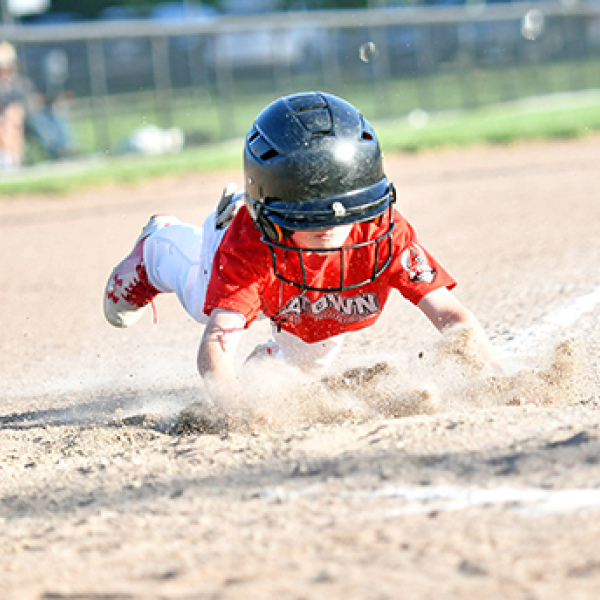 Walker Griffith goes all-out with an aggressive head-first slide into home plate. 