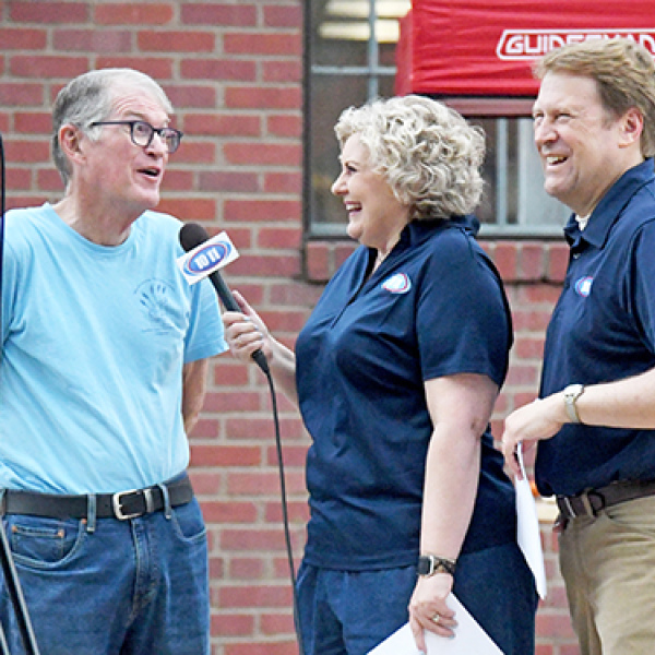 Channel 10/11 TV news anchors Taryn and Jon Vanderford (right) interview Hamilton County Food Pantry board member Bruce Ramsour during the annual Can Care-A-Van food drive last week.