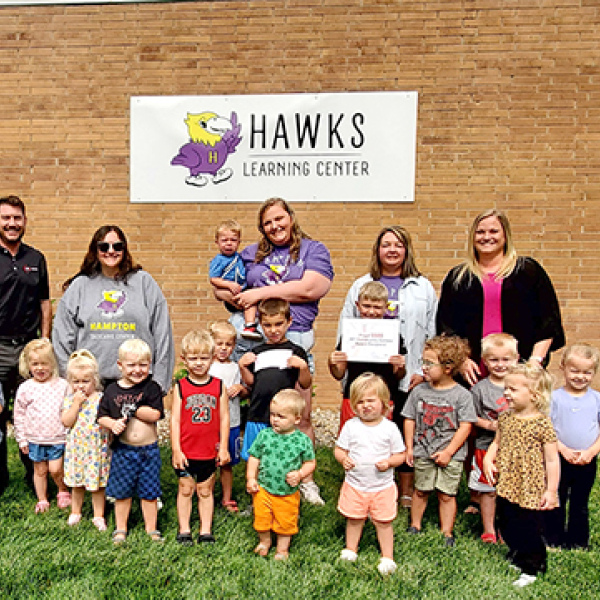 Children and staff members of the Hampton Community Daycare Center line up for a photo after receiving a $500 Community Contest Award. 