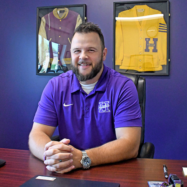Carson Klute sits at his desk in the superintendent’s office at Hampton Schools a few days before the start of the new school year. The Hampton High School grad took over the position July 1 and said he was looking forward to the new school year. Klute’s family history at Hampton is evidenced by his grandfather Fred Klute’s Hawks letter jackets on the wall behind him. His father’s Hampton High School diploma hangs on another wall. 