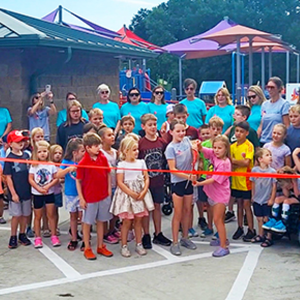 A group of children prepares to cut the ribbon signaling the opening of the Hamilton County Inclusive Playground.