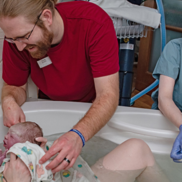 Elizabeth Mollard (right) assists with a water birth at St. Elizabeth Regional Medical Center in Lincoln on March 10, 2022. (Photo by Leslie Moon/Novita Birth Stories)