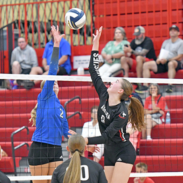 Aurora’s Elizabeth Luebbe and Malcolm’s Payton Dolliver go for the same ball at the top of the net in what was a three-set winner for the Huskies. 