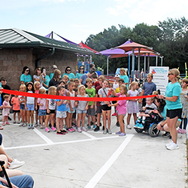 A group of children prepares to cut the ribbon to officially open the Hamilton County Inclusive Playground on Saturday morning. 