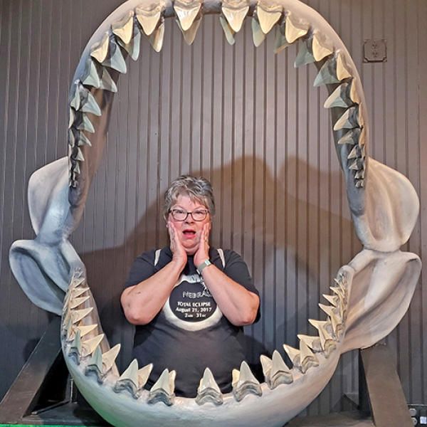 Patti Kell poses for a picture inside the jaws of a massive ancient shark at a fossil museum in Aurora, N.C.  