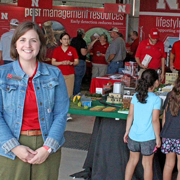 Extension Educator Jordan Grummert Rassmussen stands inside the Big Red Building at the recent Husker Harvest Days where various Extension booths were located. Rassmussen is the program area leader for Rural Prosperity Nebraska, an Extension program that helps rural communities develop new leaders and plan for the future. 