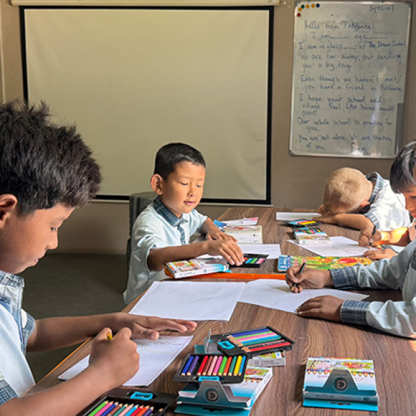 The Dream School is working with their students and families to help assemble 300 backpacks containing school supplies for children who lost their belongings. Students at The Dream School are pictured here creating cards to include in the backpacks.