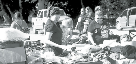 Ashley Vollers and her daughter Aspen of St. Paul were among the many people checking out the tables filled with items at the Westside Covenant Church during the two-day citywide garage sale. News-Register/Kurt Johnson