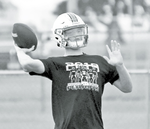 Above: Aurora quarterback Ethan Shaw lets one go during the Huskies’ first practice of the 2020 season Monday morning. At right, Gage Griffith goes through an offensive lineman drill during the first day of practice. News-Register/ Richard Rhoden