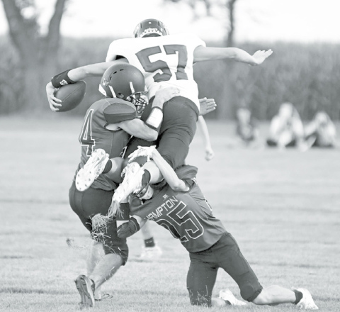 Above: Tackling was key through most of the night for Hampton as Andrew Adams (left) and Austen Adams combine for the stop. At right, Evan Pankoke (24) comes in to wrap up as Tyson Wolinski hangs on for dear life. News-Register/Richard Rhoden