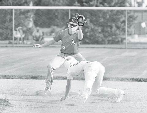 Aurora Cooperative Red shortstop Jayson Havens fields a perfect throw from home plate and slaps the tag on Pinnacle Bank White’s Trevor Moeller during Thursday’s 7-1 win. News-Register/ Richard Rhoden