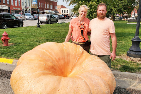 Beth Wood (left) and her boyfriend Traver DeMaranville pose with the second-place, 1,365 pound pumpkin at a competition in Bloomfield, Iowa.