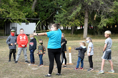 Alicia Epp gives lessons on how to hold and aim a bow and arrow to a group of attentive listeners.