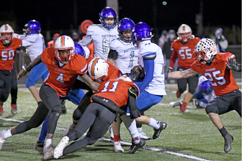 The Husky defense of Mack Owens (4) Brady Collingham (11) and Jameson Herzberg (25) converge on the hit during Aurora’s 21-12 win over Plattsmouth.