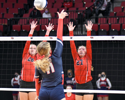 The Schuster sisters of Jaylee (28) and Kasey reach for a block during Aurora's three-set loss to Norris Wednesday. 