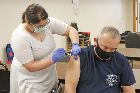 CDHD representative Kamrie Peterson (left) administers the very first Pfizer COVID-19 vaccine in Hamilton County to Aurora Fire Chief Tom Cox.