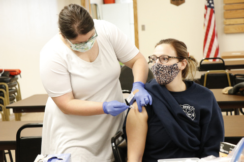 CDHD worker Kamrie Peterson, left, administers one of a limited number of Pfizer COVID-19 vaccines to Aurora Fire and Rescue’s Sara Newton. 