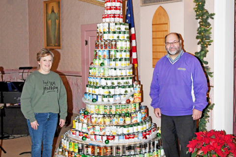 Sharon Klute (left) and Pastor David Feddern stand next to the can tree that totaled 1,230 cans to be donated to the Hamilton County Food Pantry.