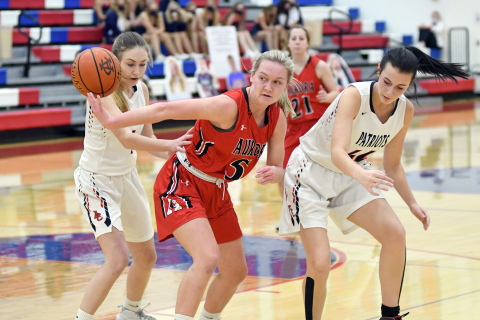 Aurora’s Jaylee Schuster flips the ball behind her in heavy traffic during the Lady Huskies’ 56-38 loss to Adams Central Thursday night.
