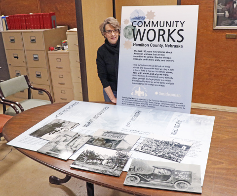 Tina Larson, executive director of the Plainsman Museum, stands proudly with some of the panels that will be on display for their Community Works exhibition. 