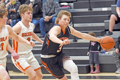 Giltner’s Tanner Roth looks to drive past two Osceola players during Friday’s 51-35 loss to the Bulldogs.