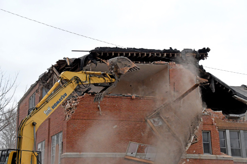 The demolition crew forces out a window frame from the top floor as they slowly work to clear the sections nearest the event center.