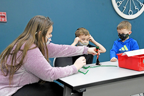 Journey Noyes (left) helps students in the after-school club work on a science experiment. She along with Sydney Dyer assist with camps, clubs and daily activities. 