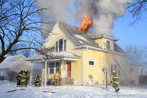 Flames shoot out of the Donald and Kelsey Adams house during an early Tuesday morning fire in Aurora.
