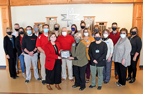 Diane Keller, CEO of Memorial Community Health, is presented a plaque along with other members of the staff recognizing MCHI as the Aurora Chamber of Commerce large business of the year.