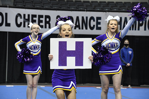 Senior Lexie Wolinski, front, leads a chant with help from cheer teammates Kennedy McCullough, left, and Kaylei Joseph.