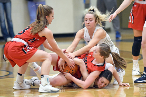 A battle for a loose ball gets intense as Aurora’s Raina Cattau (middle) holds on for dear life as teammate Cassidy Knust comes in to assist.