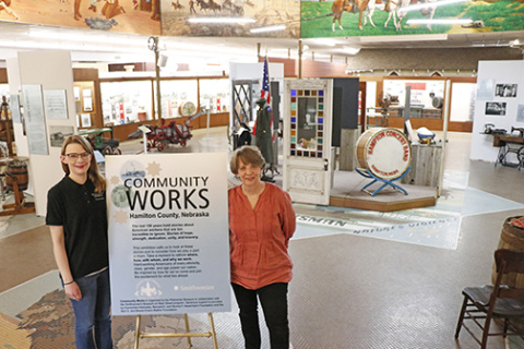 Katherine Larson (left) and her mother Tina Larson, Executive Director of the Plainsman Museum, stand amidst the completed Community Works exhibition, on display officially April 6.