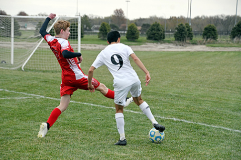 Blake DeVries plays tough defense near the goal during Aurora’s 7-0 loss to Lexington at home Thursday. 