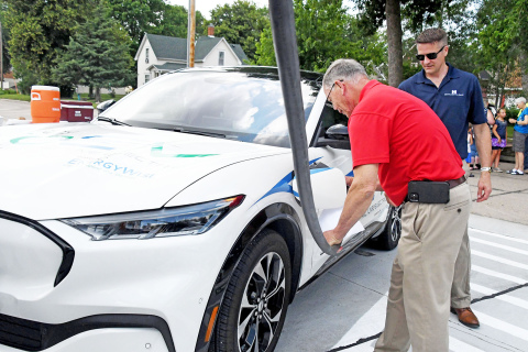 Mayor Marlin Seeman (left) got to go through the process of charging an electric vehicle during the ribbon-cutting June 25.