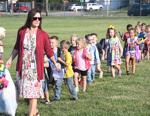 Kim Staehr leads her kindergarten class in for the first day of school.