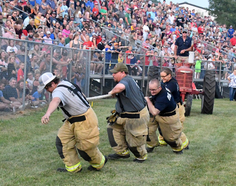 Four Aurora firefighters team up in the "Kid at heart tractor tug" event.