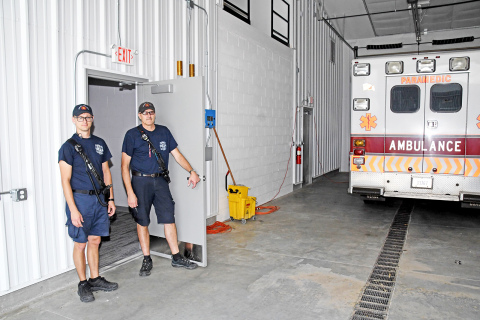 EMS Captain Brent Dethlefs, right, and crew member Chris Hyde stand in the doorway which connects the city’s new EMS living quarters to the ambulance bays.