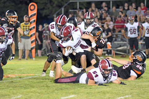 Giltner’s defense, including pictured players Jax Wiesen (22) and Connor Craig (88) wrestle Heartland’s Kale Wetjen (4) to the grass during Giltner’s 52-14 loss to the Huskies in the season-opener Friday night.