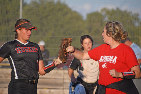 Rylee Olsen gets a fist/glove bump from coach Ashton Voss after throwing another shutout inning in a home game against David City. Olsen gave up only one run in an 11-1 victory.